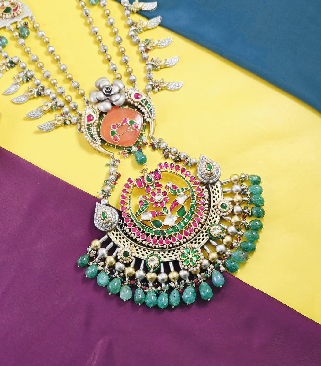 Ornate necklace with colorful beads on a multicolored fabric background